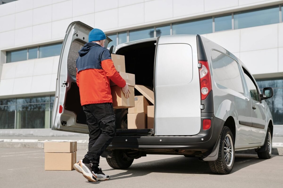 a man in a jacket loading boxes in a van