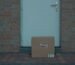 a brown cardboard box beside white door